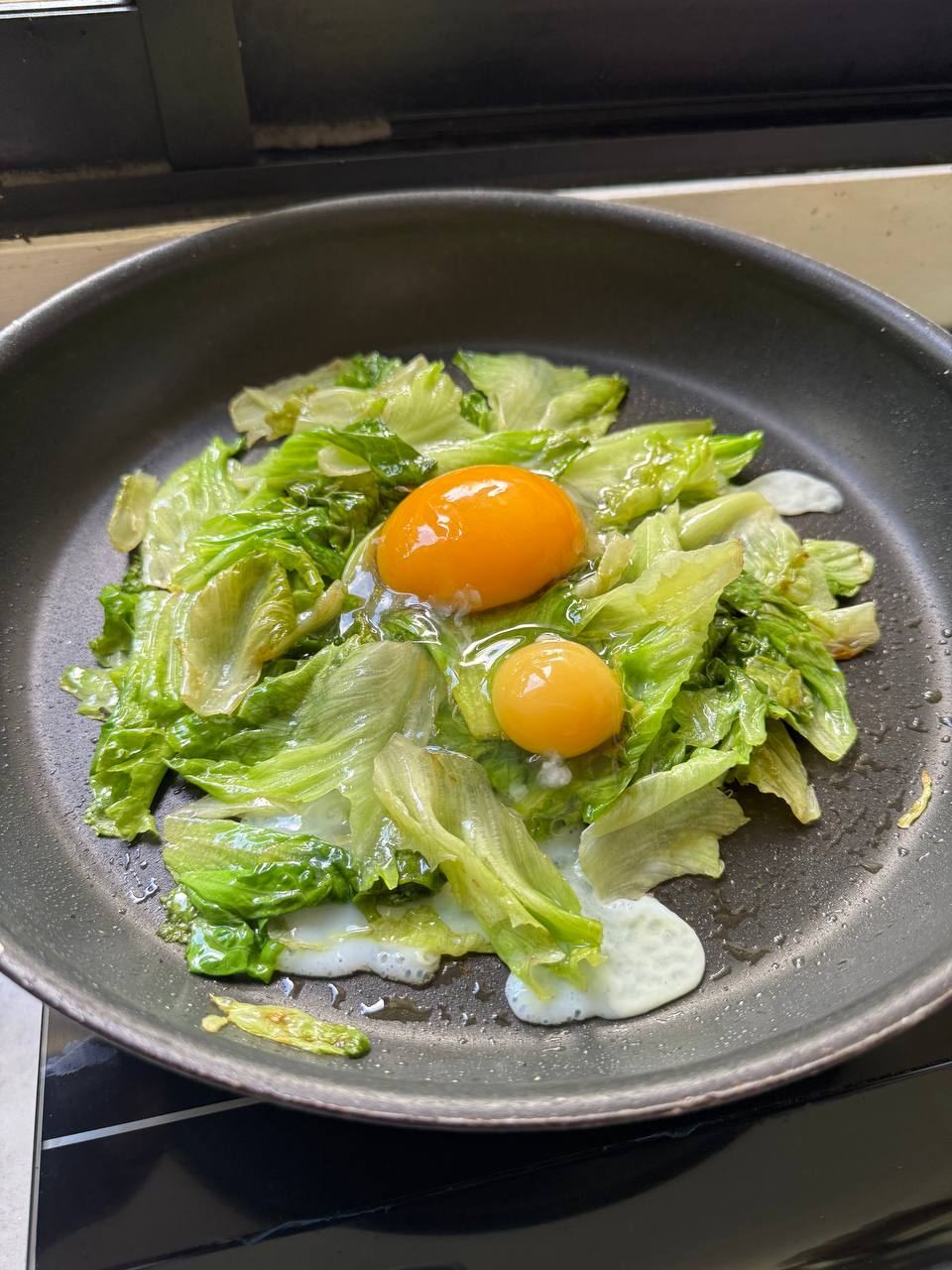 Eggs with garden greens in the pan